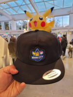 Pokemon-Rain-City-Showcase-Hat-150x200.jpg